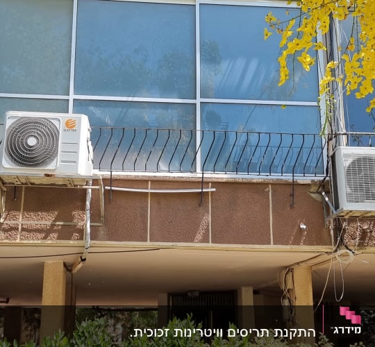 תריסים לבנים על חלונות בניין עם מזגנים